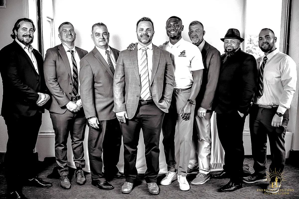 A group of guests stands together at the Legends Among Us luncheon.