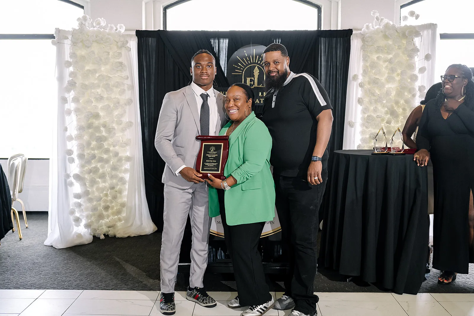 Jaylen McClain presents an award to Brick City Lions at the Legends Among Us luncheon, May 30, 2026.